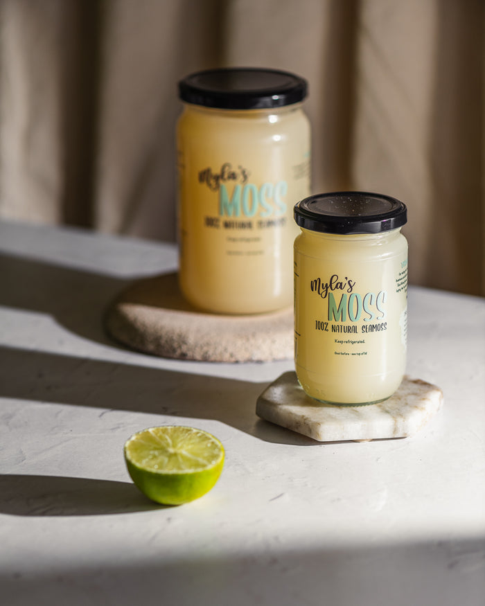 Two jars of Myla's Moss sea moss gel in different sizes on stone coasters with a halved lime, representing the Saver Bundle's 340ml and 720ml sizes.
